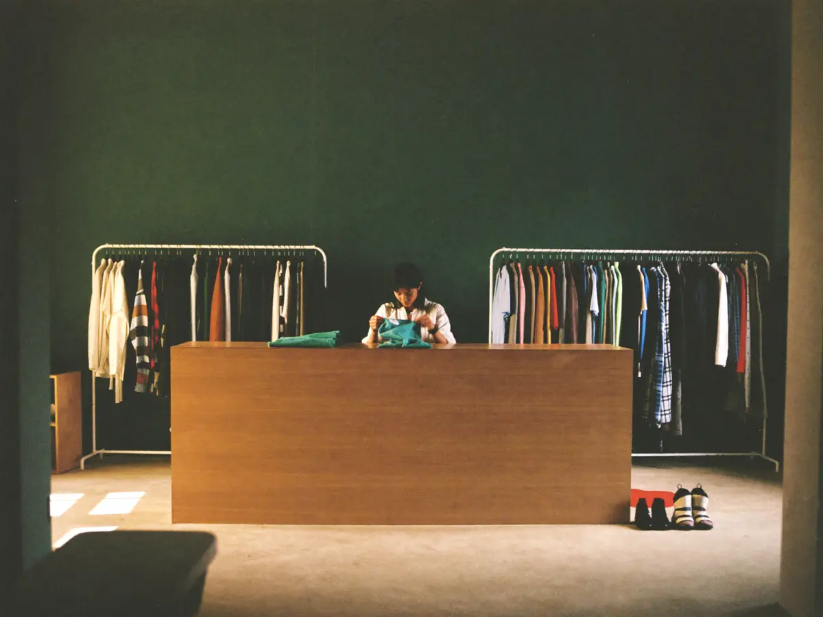 A quiet clothing boutique with garments spaced along the rails.