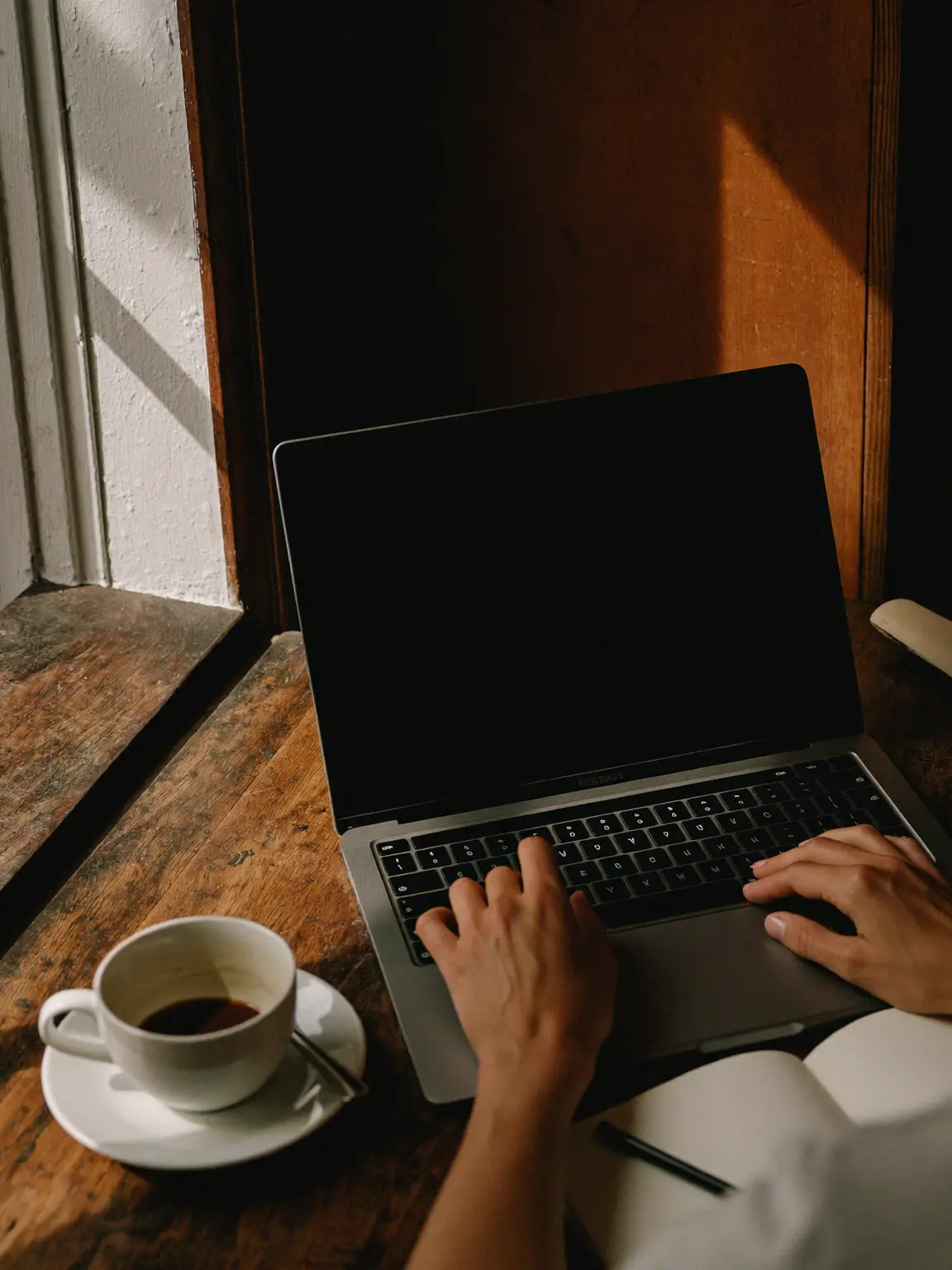 The journal open on the counter at first light — the new post a sentence in, last published eight months ago.