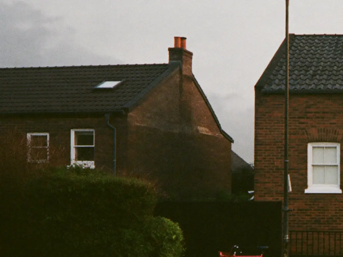 A row of brick terraced houses on a quiet street in flat morning light.